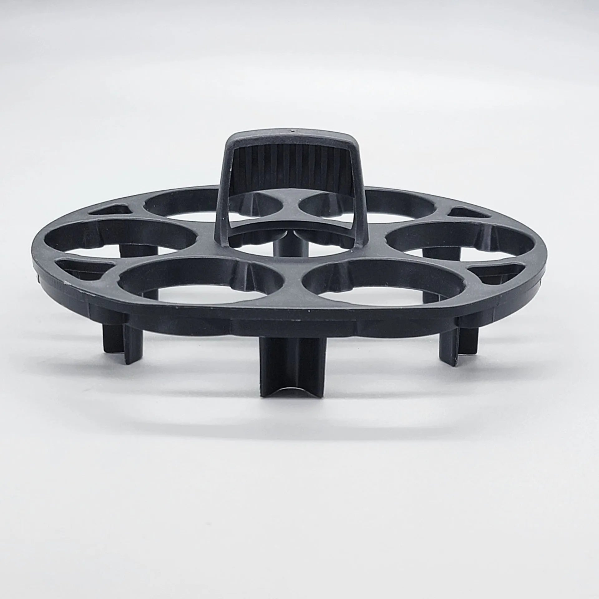 Black plastic egg holder basket rack for a cooking machine on a white background.
