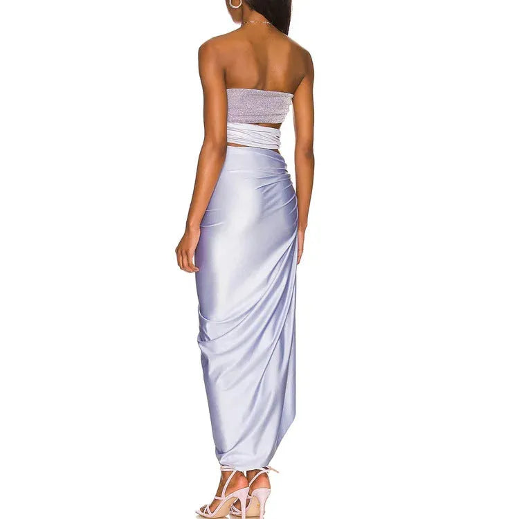 Purple one-piece swimsuit and matching wrap skirt set laid flat.