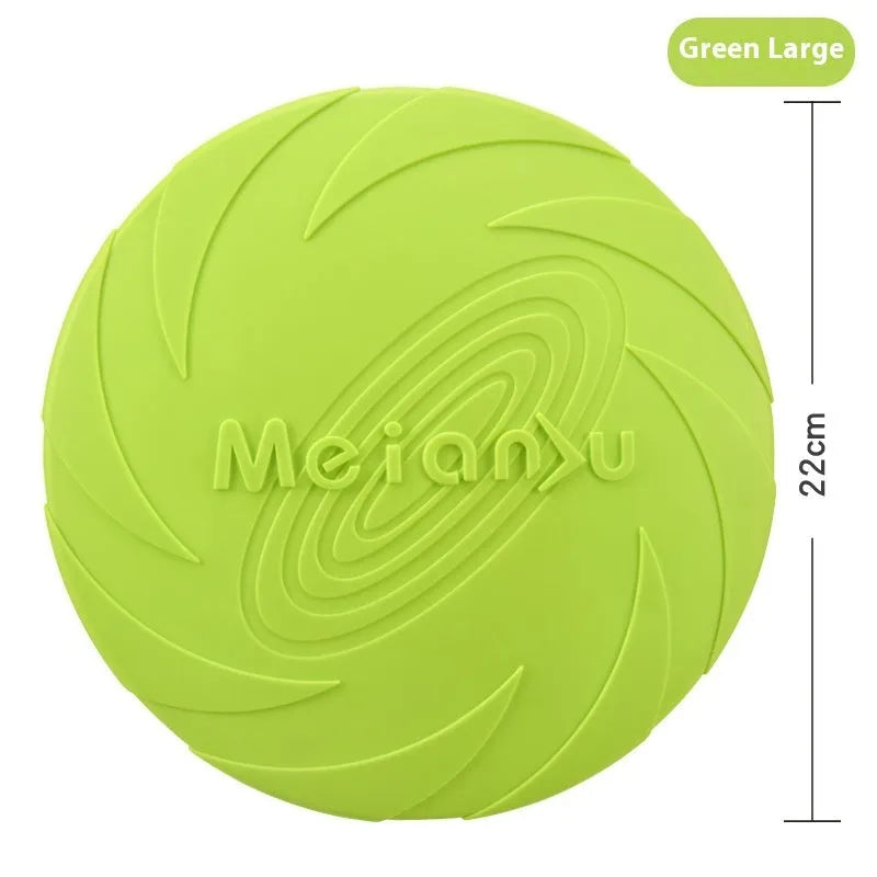 Soft rubber dog frisbee toy in blue, shown on grass for scale.