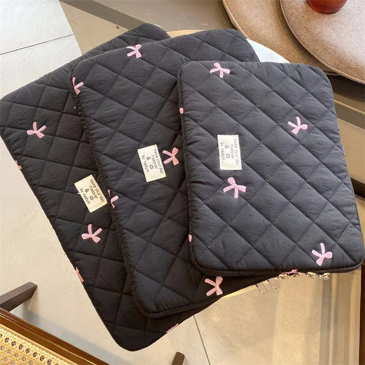 Nylon laptop storage bag with embroidered rhombus bow in light blue, showing size options.