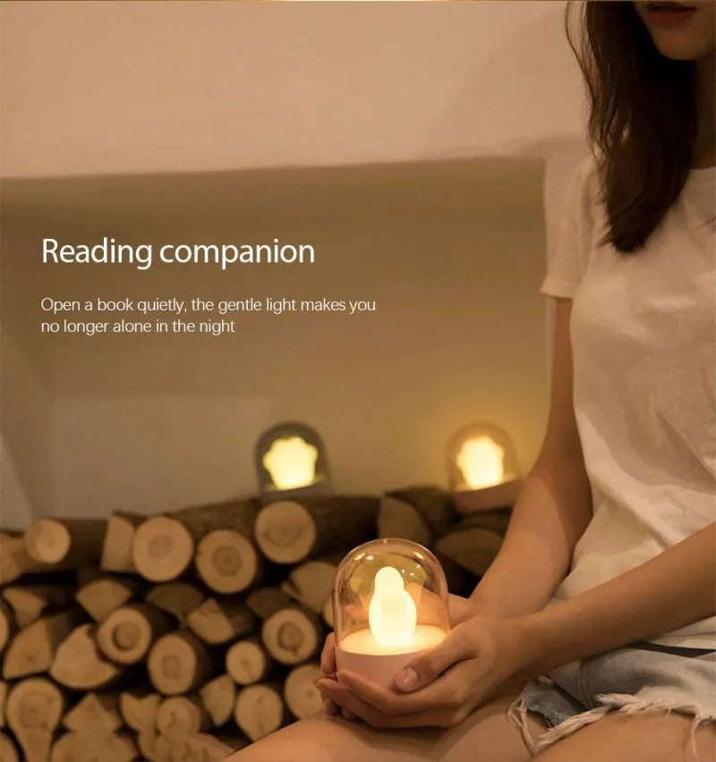 Grey or pink cat paw shaped USB rechargeable night light with musical functions on wooden desktop