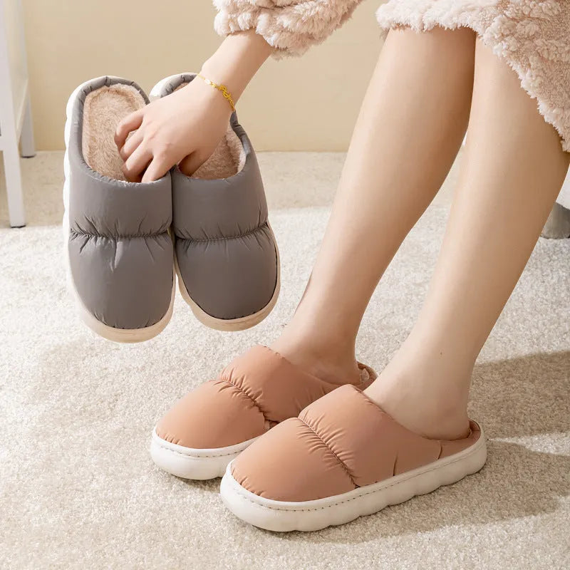 Pair of down cotton indoor slippers with artificial leather upper and thick rubber sole.
