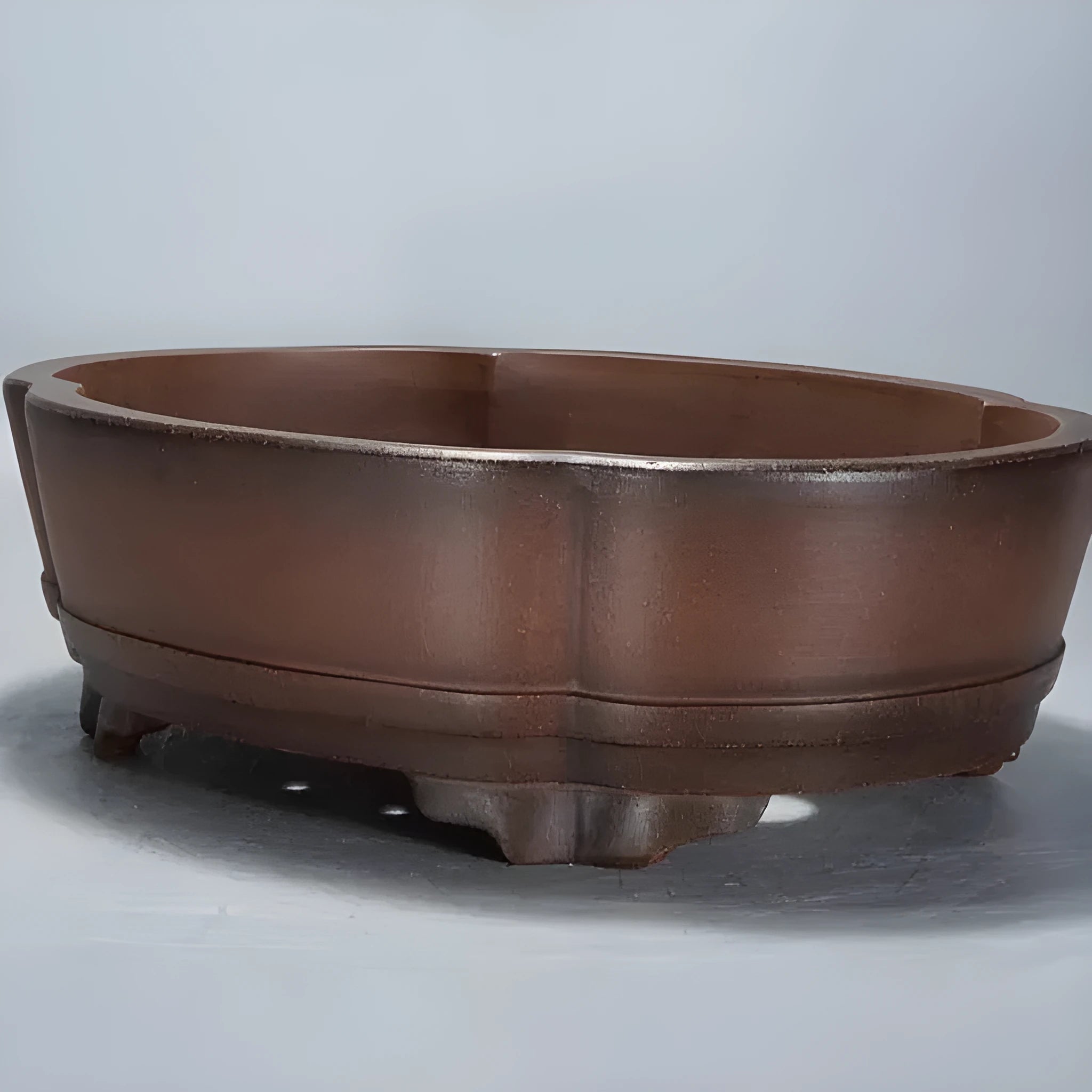 A classical simple purple clay bonsai pot on a tabletop.