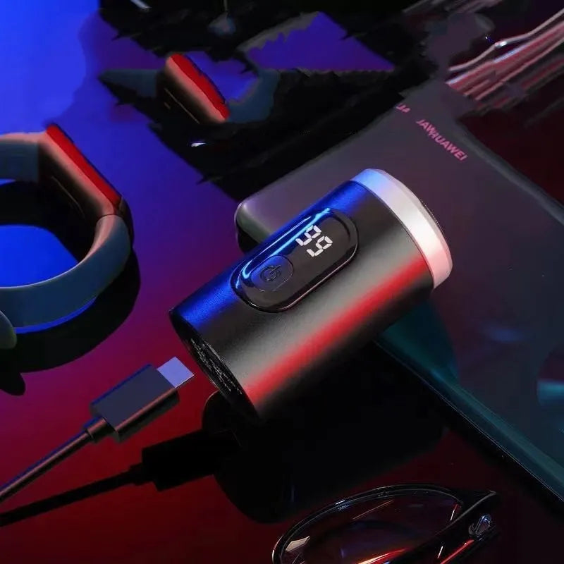Black mini rechargeable shaver with USB cable and cleaning brush on a table