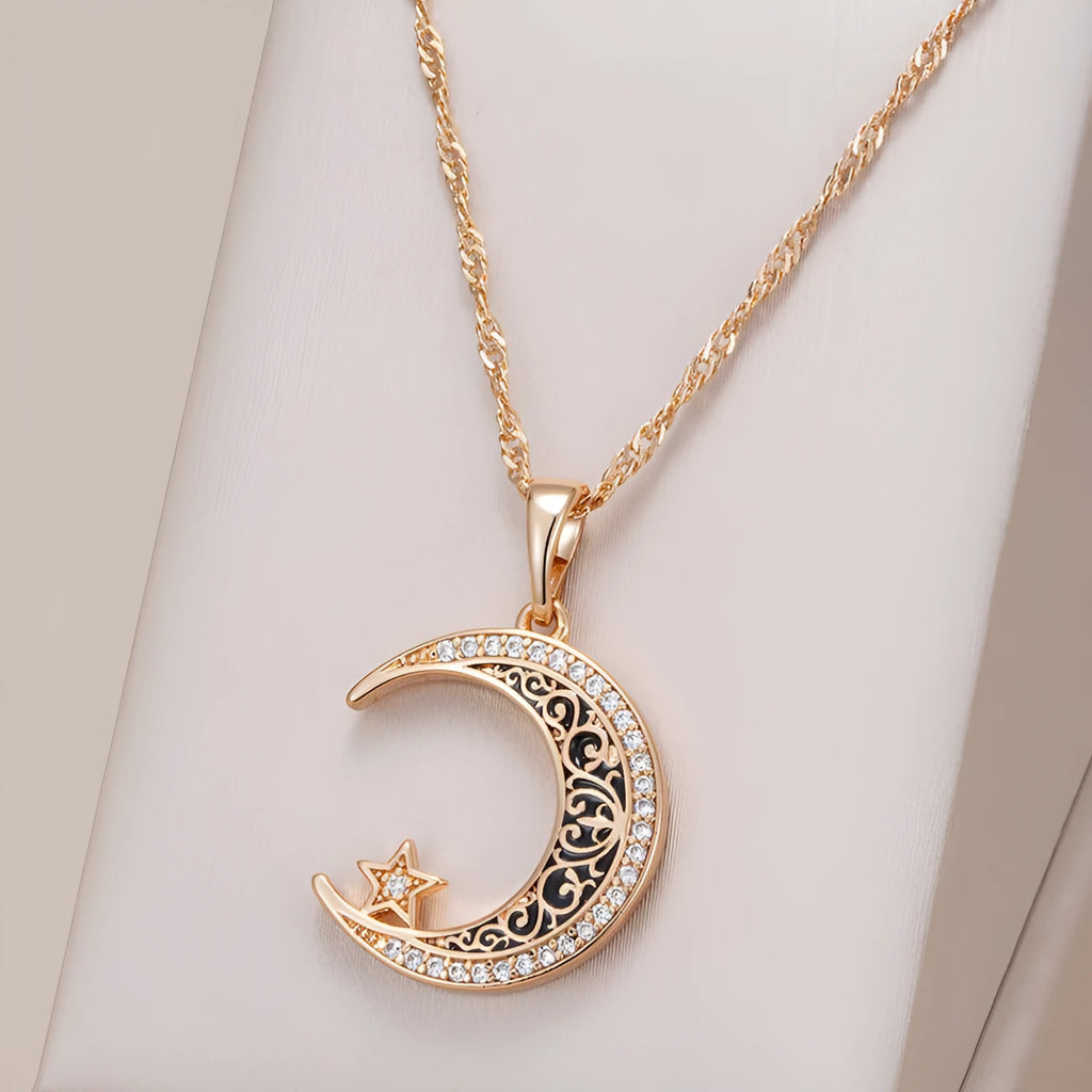 Rose gold-tone moon and star pendant necklace with enamel details on a water wave chain.