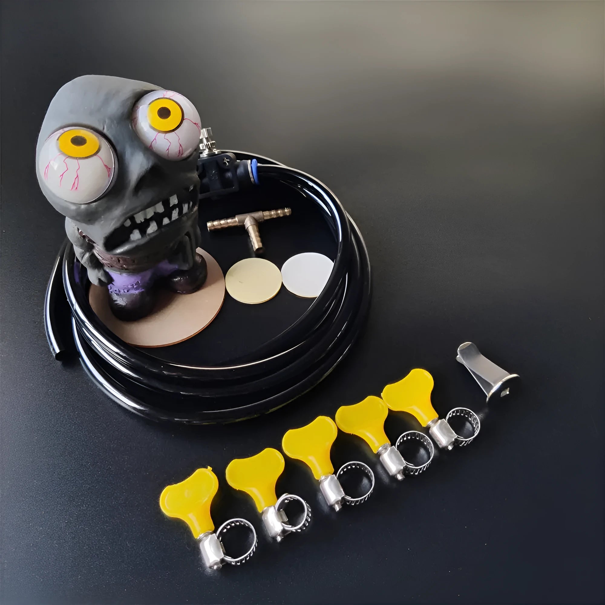 Car turbo boost sound kit with explosive eye doll, pressure valve, copper tube, and fittings on a dark background.