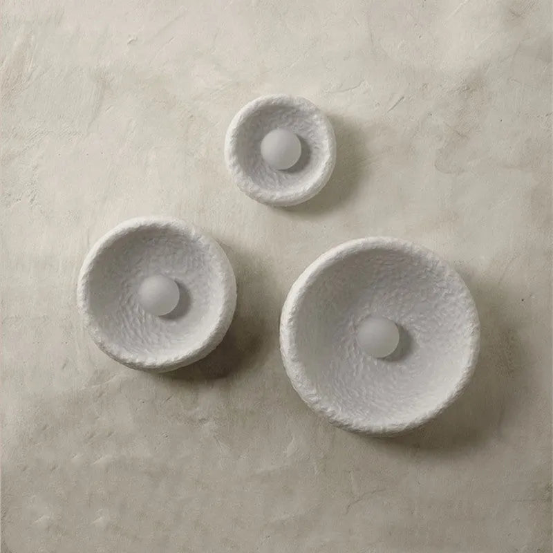 Japanese-style simple silent wall lamp with white resin shade on a wall.