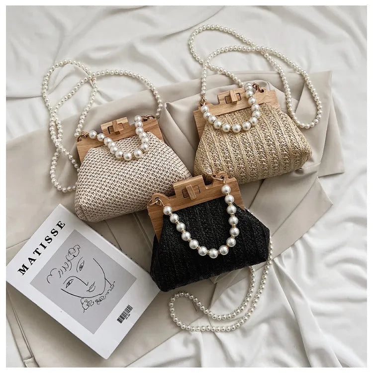 Women's woven straw shoulder bag with pearl chain strap showing interior organiser compartments