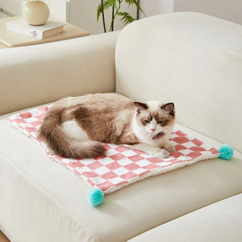 Green plaid pattern pet blanket with soft fleece texture on sofa