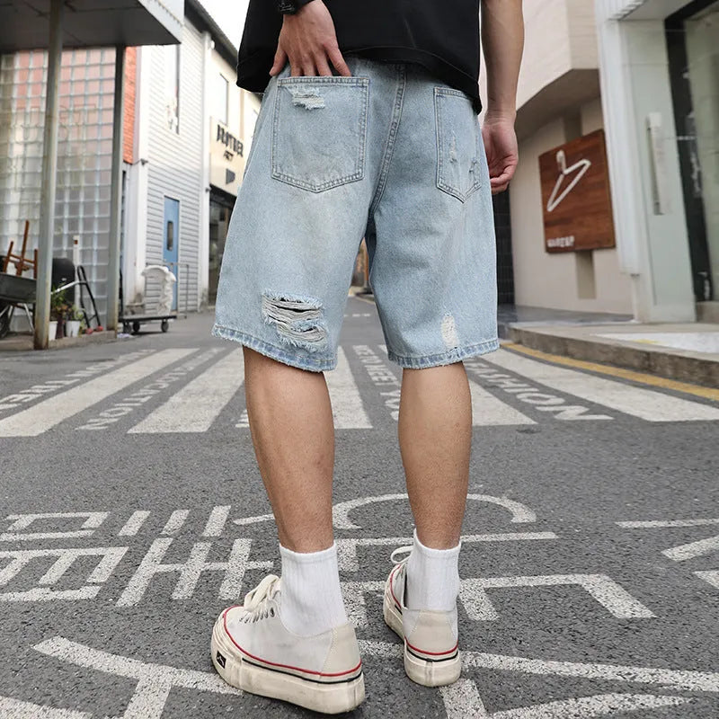 Light blue ripped denim shorts with distressed detailing and loose straight cut fit
