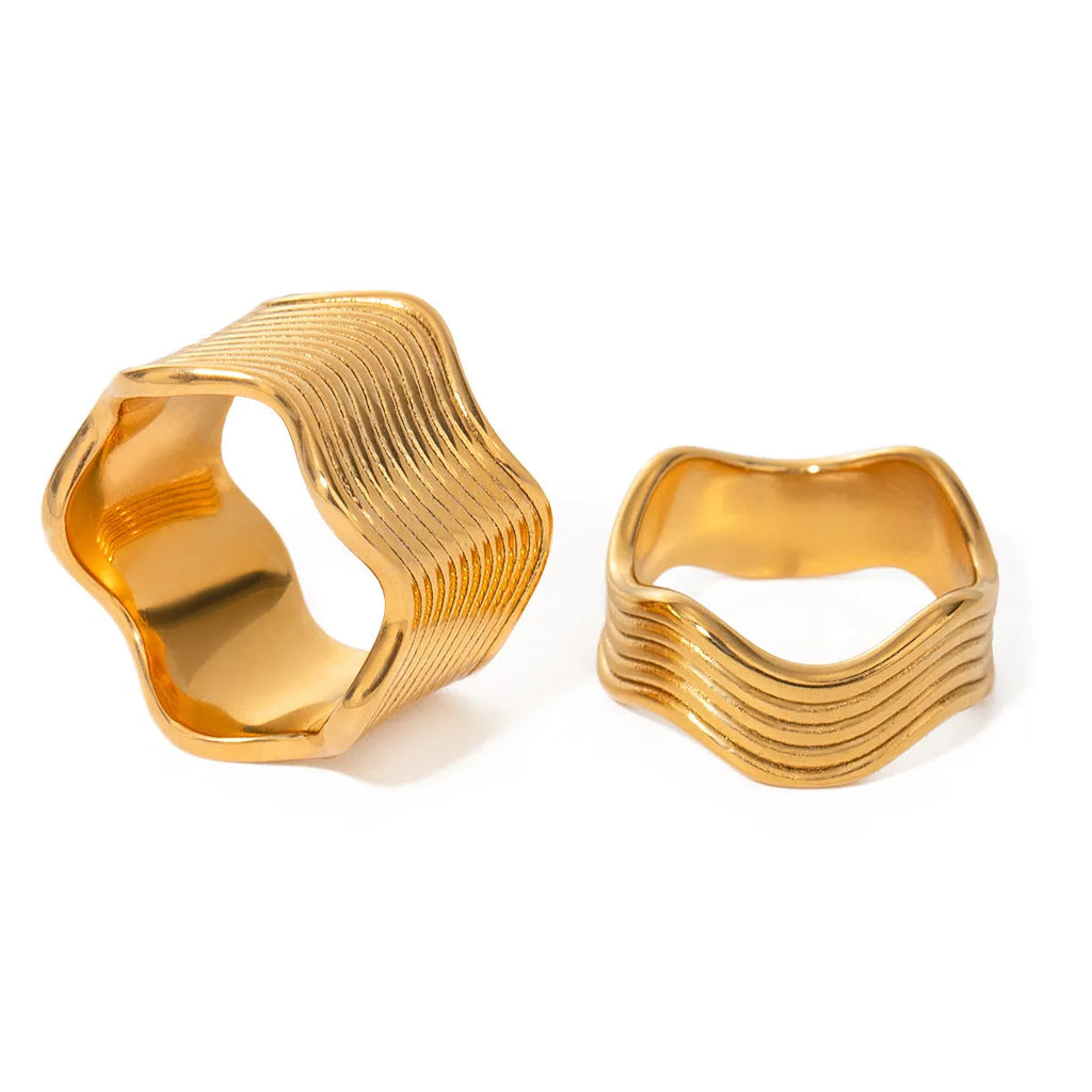 Stainless steel women's ring with a wide geometric wave surface design in a silver or gold finish.