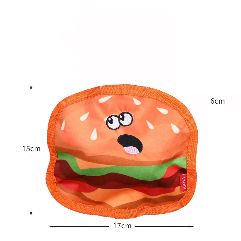 Hamburger-shaped dog chew toy with red, yellow and brown colours showing crinkle and squeak features