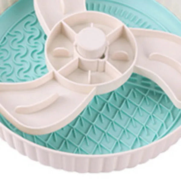 Grey rotating pet slow feeder bowl with a blue silicone windmill-pattern licking mat attached.