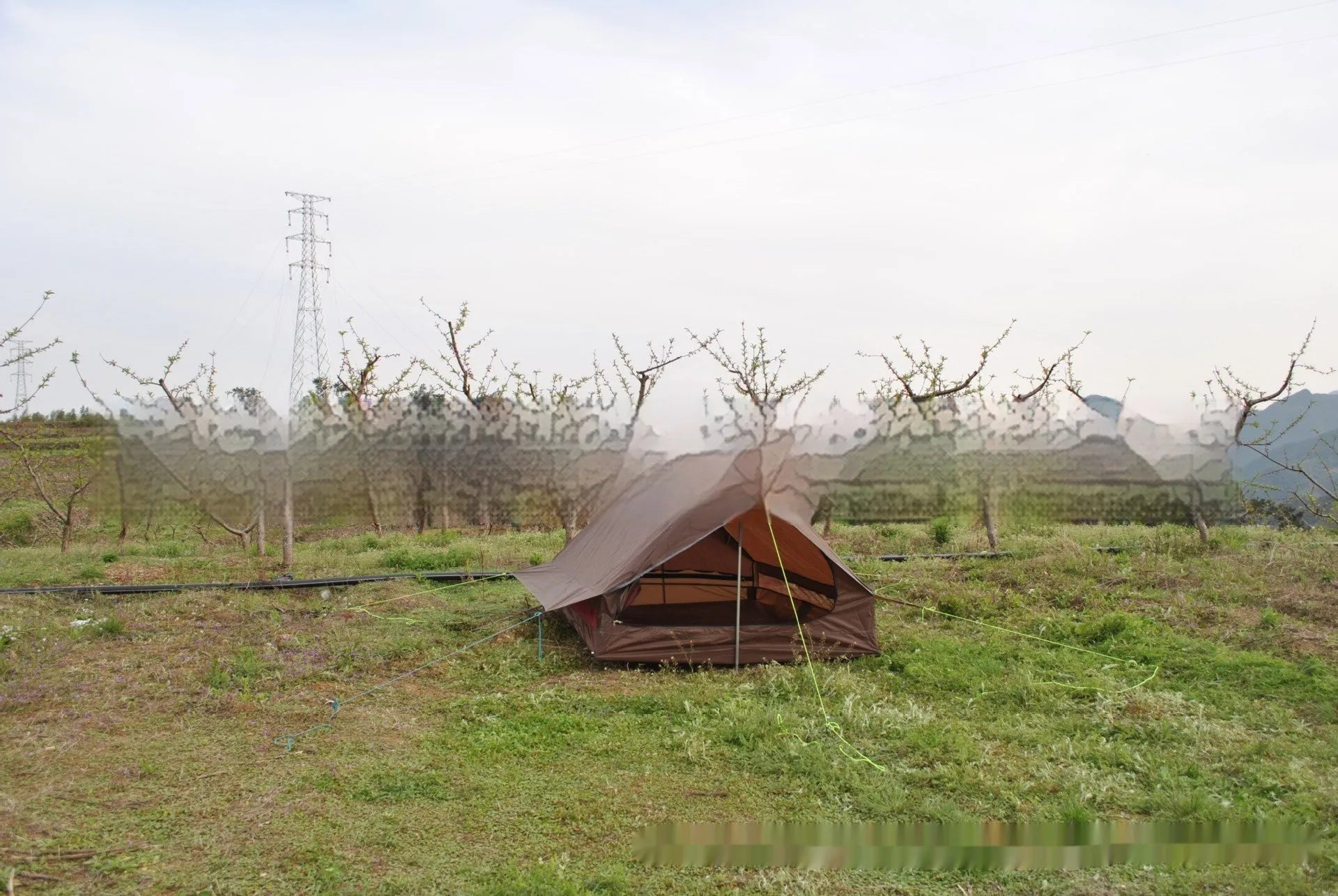 Brown or white A-line hiking tent without poles, supported by hiking canes