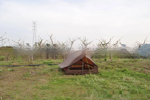 Brown or white A-line hiking tent without poles, supported by hiking canes
