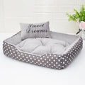 Polka dot printed square dog bed with raised bolsters and a matching embroidered pillow.