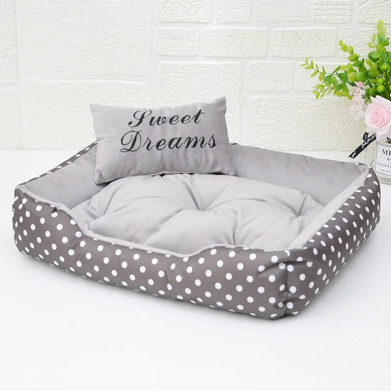Polka dot printed square dog bed with raised bolsters and a matching embroidered pillow.