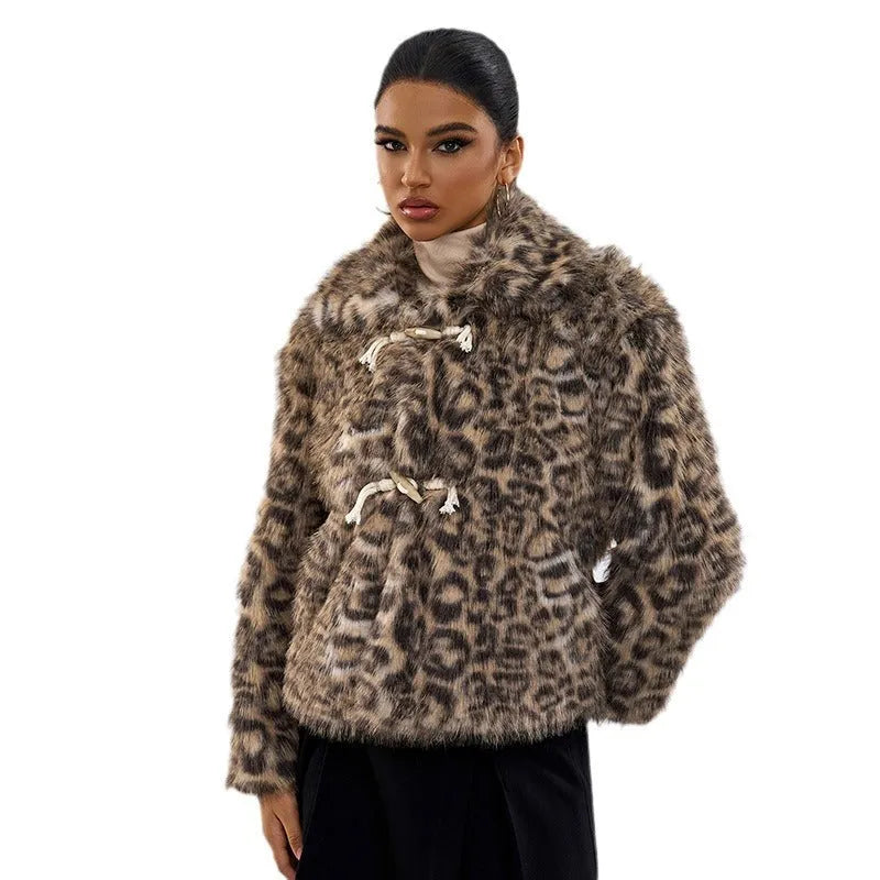 Women's leopard print coat with a buckle lapel fastening, shown in street fashion style.