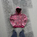 A man's loose-fitting red hooded zip coat with long sleeves, shown on a hanger.