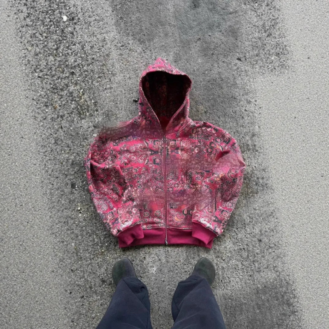 A man's loose-fitting red hooded zip coat with long sleeves, shown on a hanger.