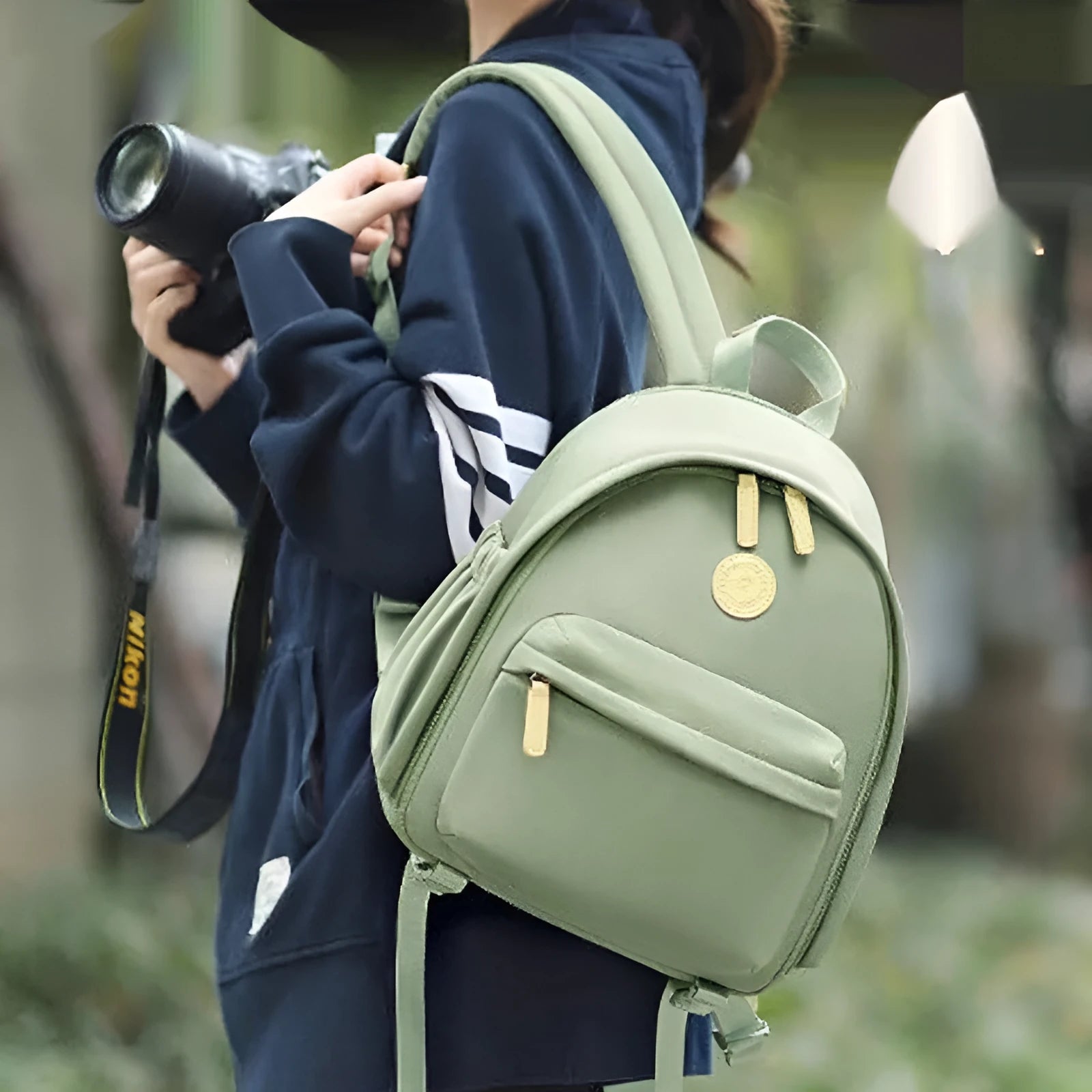 Women's polyester shoulder camera bag in black with a curved strap and detachable iPad pocket.