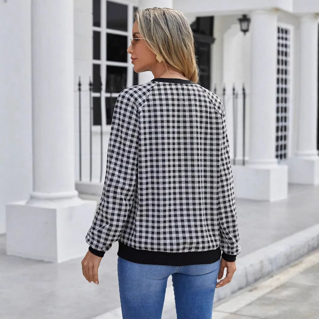 Black long sleeve pullover sweater with a striped plaid pattern and printed design detail.