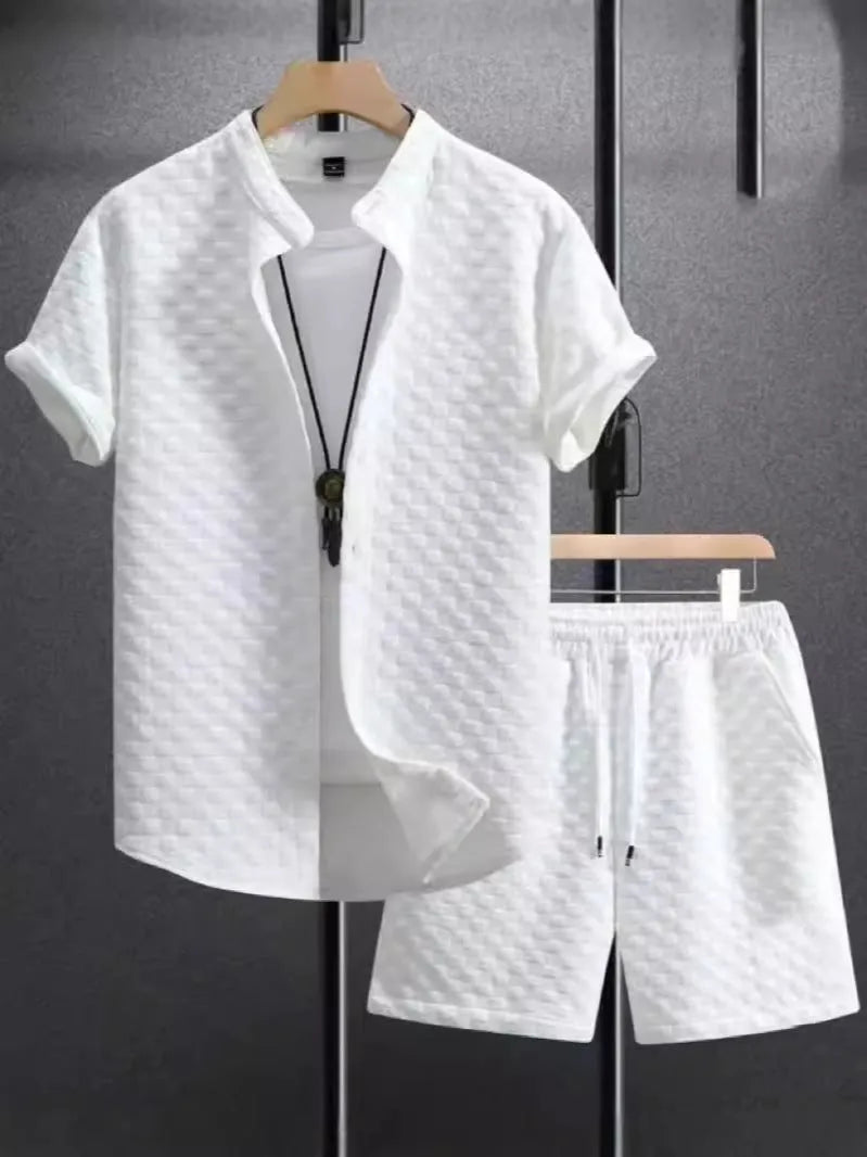 Man wearing a jacquard black short sleeve suit shirt with matching shorts from a two-piece set.