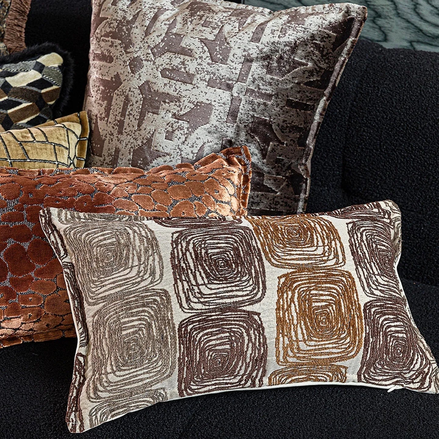 Square and rectangular pillow covers with abstract cream and coffee coil pattern on polyester fabric.