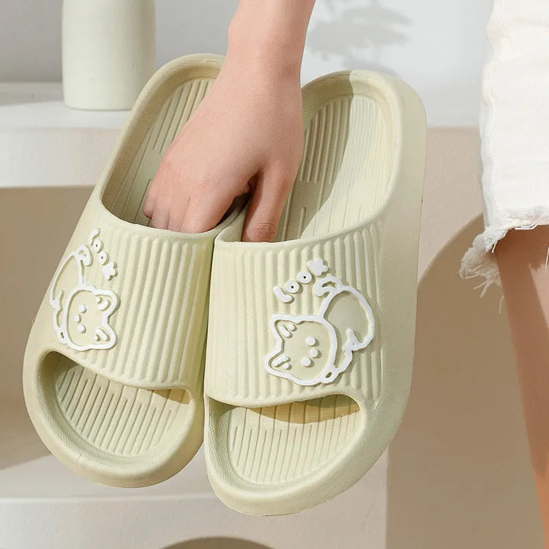 Green cat design thick EVA platform slippers on a wooden floor
