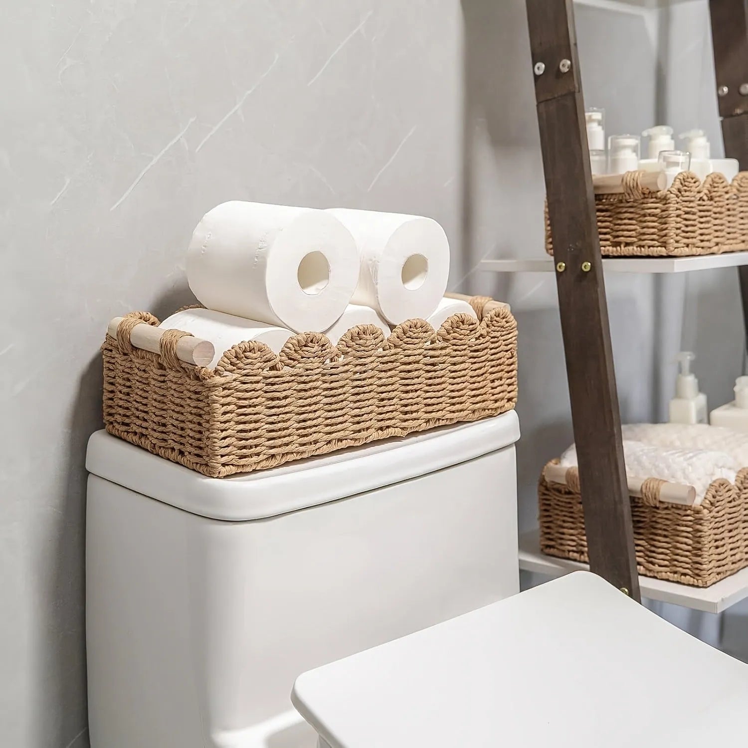 Modern woven paper storage basket in khaki colour on a wooden desktop, holding remote controls and pens.