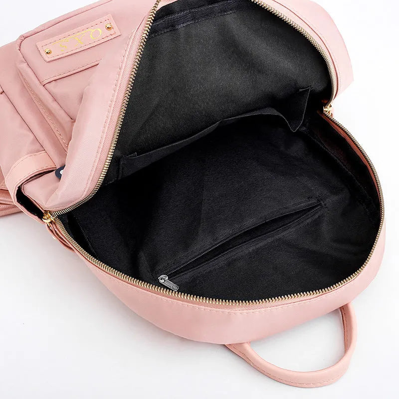 Women's black nylon casual backpack with double shoulder straps showing internal compartments and waterproof features