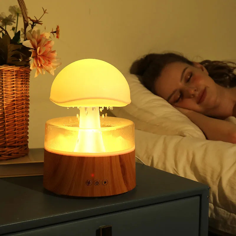 White cloud rain humidifier with rainfall simulation and LED lighting on wooden surface