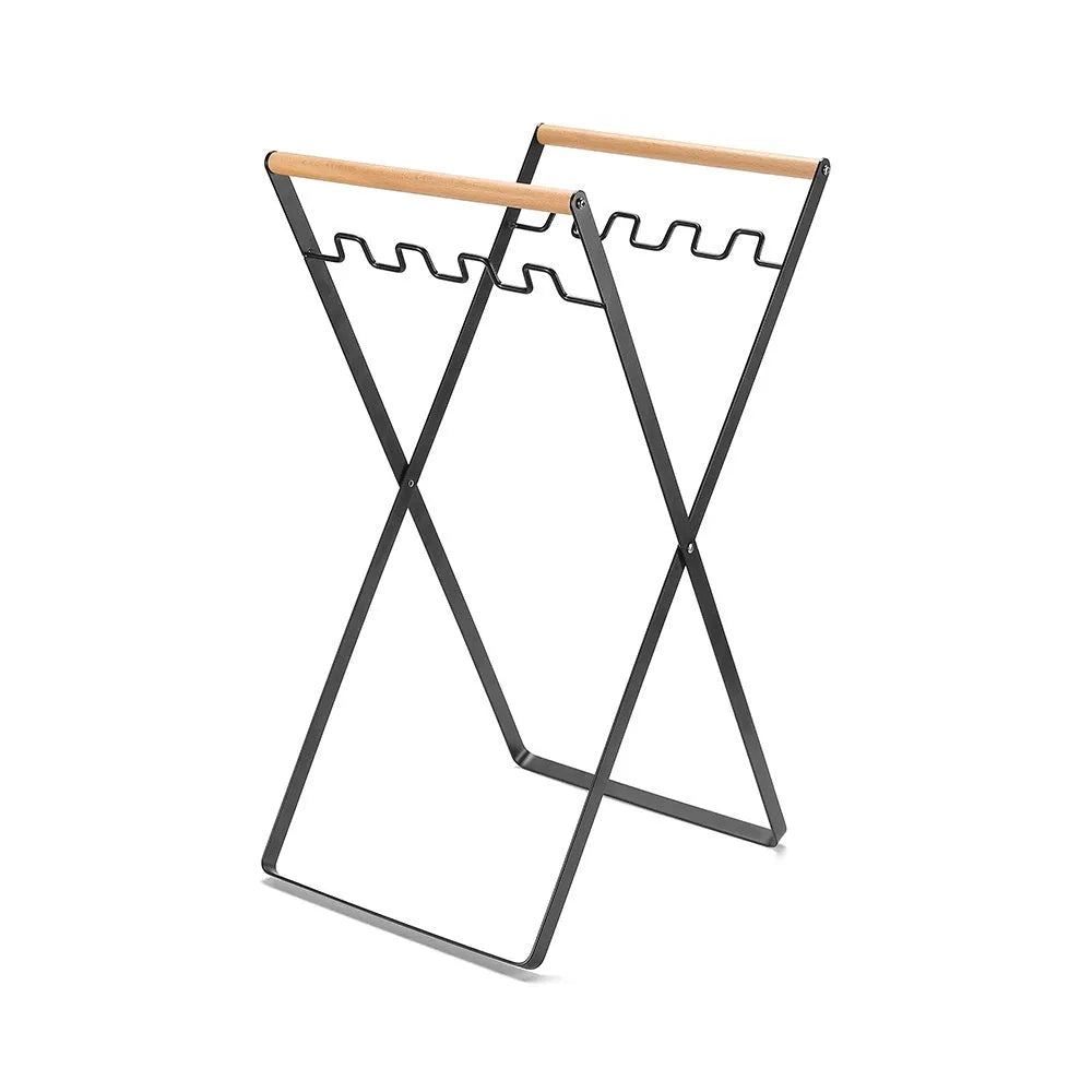 Black folding outdoor trash rack with a wooden handle, holding a rubbish sack.