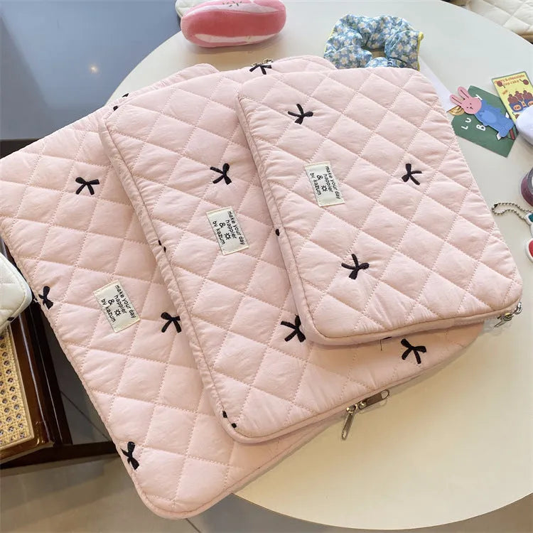 Nylon laptop storage bag with embroidered rhombus bow in light blue, showing size options.