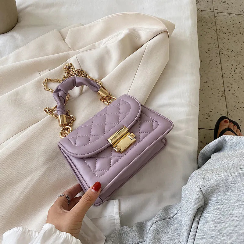Purple rhombus-shaped small square shoulder bag with crossbody strap against neutral background
