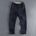 Men's khaki cotton work trousers with three-dimensional cutting and a silver N I buckle belt on the waist.