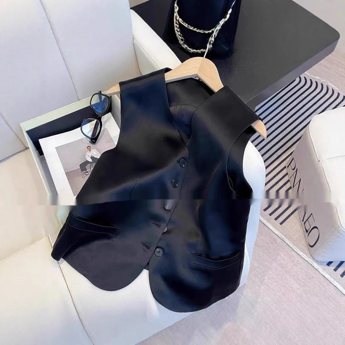 Black satin sleeveless loose-fit vest for women on a hanger