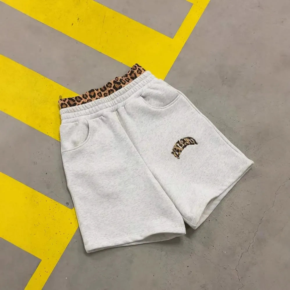 Man wearing grey patchwork loose fit hip hop trousers with a double waist design and a matching top.