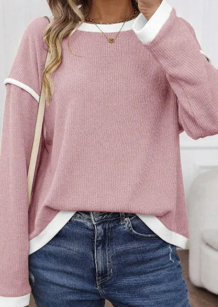 Woman wearing a green four leaf clover pattern loose knit top with drop shoulders and contrast trim