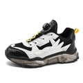 Men's black casual shoes with a rotating button closure and mesh upper on a rubber sole.