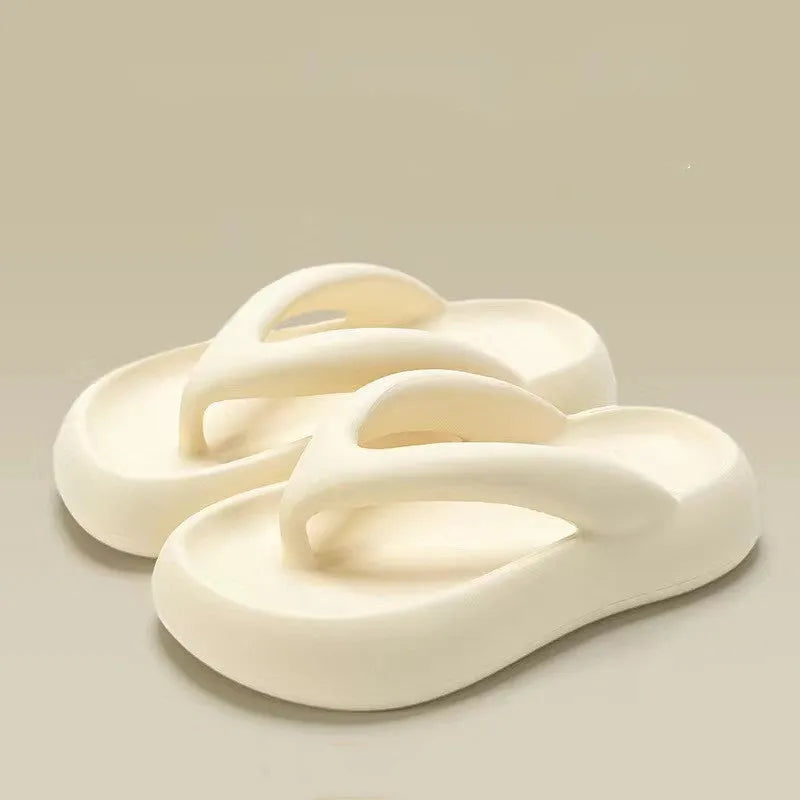A pair of thick-soled flip-flops with a bow detail on the upper, shown in a solid colour.