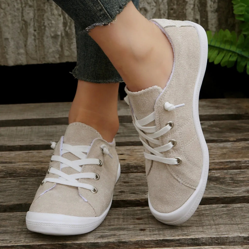 Women's creamy white low-top fabric sneakers with a casual design and rubber sole.