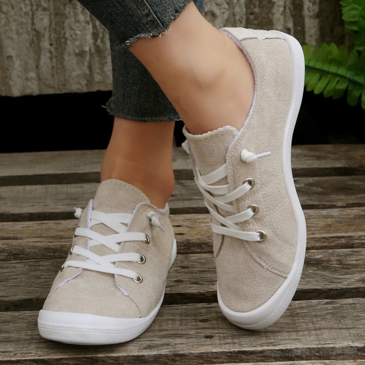 Women's creamy white low-top fabric sneakers with a casual design and rubber sole.