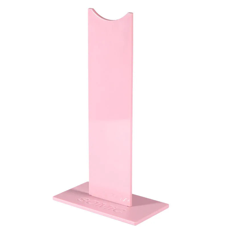 Pink and black detachable gaming headset stand with non-slip silicone base on a desk