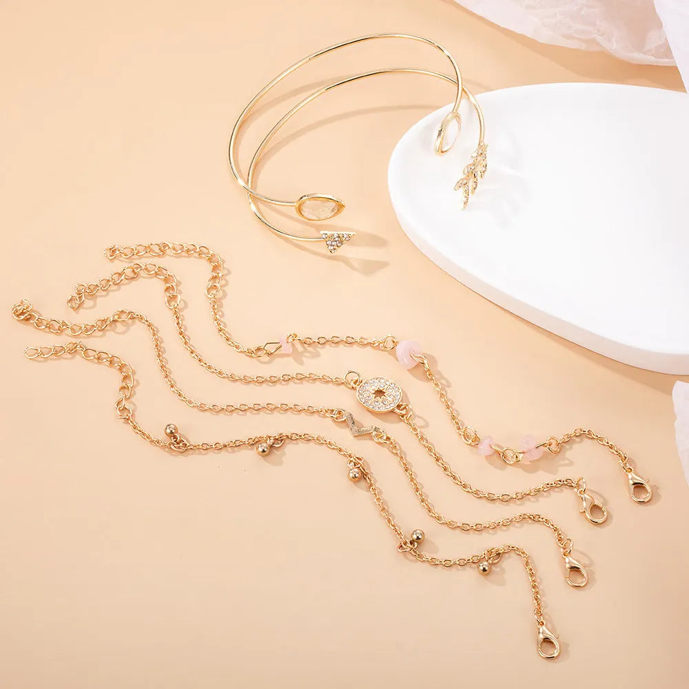 Gold-coloured zinc alloy bracelet set with arrow, water droplet, and V-shaped charms