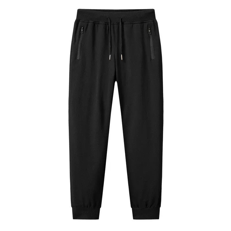Men's thin leisure tapered knitted pants in black with ankle tie, standing on a neutral background