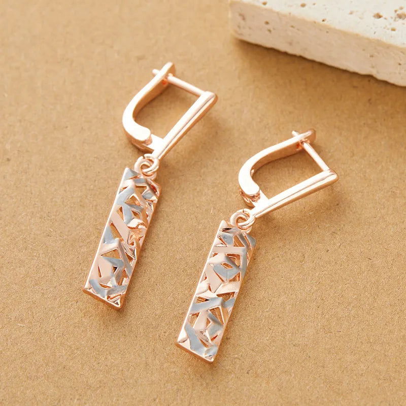 A pair of women's rectangular two-tone hollow stud earrings with a geometric design.