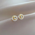 Square geometric necklace with diamond and leaf design alongside matching stud earrings