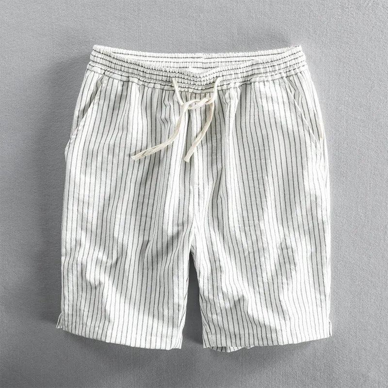 Man wearing striped light blue cotton casual shorts with a mid waist and loose straight fit.