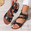 Women's black flat sandals with a Velcro strap closure, round toe, and rubber sole.